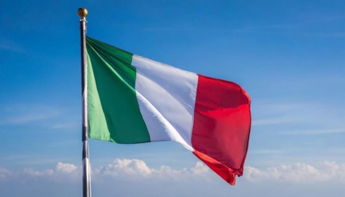 The flag of Italy flutters in the wind, isolated against a blue sky