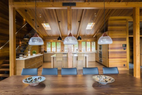 Industrial style copper with frosted glass pendant lighting fixtures over wooden dining table with