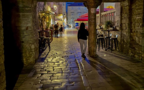 Person walking along a cobblestone street at night, Trogir, Dalmatia, Croatia, Europe