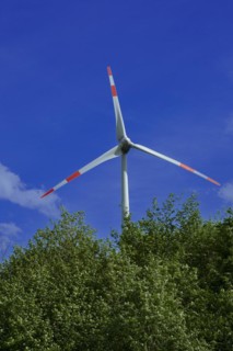 Wind turbine behind green trees at the Avacon substation Helmstedt, Helmstedt, Lower Saxony,