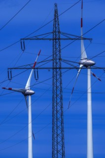 Power pylon with high-voltage lines and wind turbines at the Avacon substation Helmstedt,