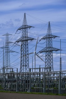 Power pylons with high-voltage lines and wind turbine at the Avacon substation in Helmstedt,