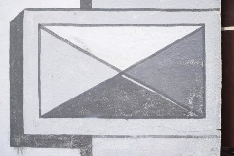 Geometric illusion painting, simulating architecture, on a historic building in the old town centre