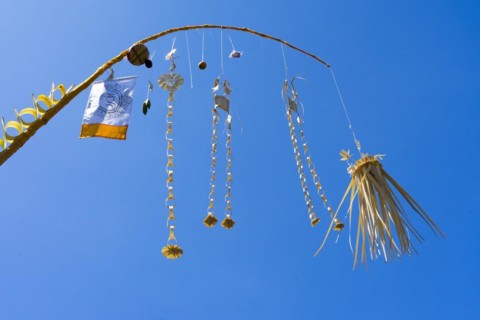 Artfully woven palm leaf jewellery on bamboo poles, on a village street in Amed, Karangasem,