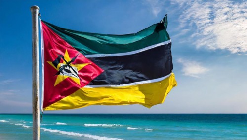 The flag of Mozambique, fluttering in the wind, isolated, against the blue sky