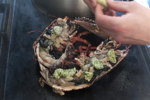 Cooked lobster (homarus) with caviar, vegetables and garlic butter on a plancha, Atlantic coast,