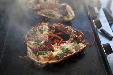 Cooked lobster (homarus) with caviar, vegetables and garlic butter on a plancha, Atlantic coast,