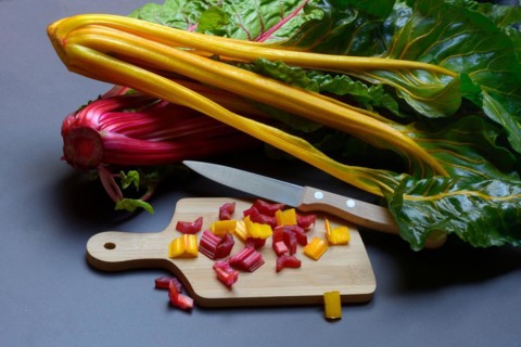 Swiss chard, chopped stems on wooden board with knife, Beta vulgaris