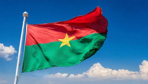 The flag of Burkina Faso flutters in the wind, isolated against the blue sky