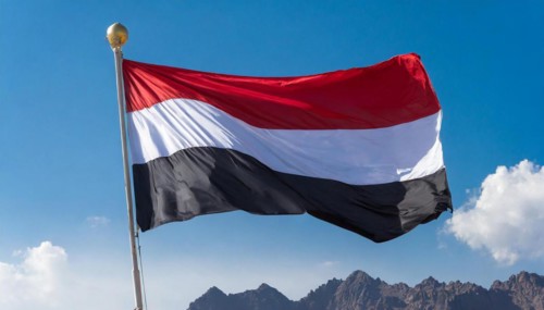 The flag of Yemen, fluttering in the wind, isolated, against the blue sky