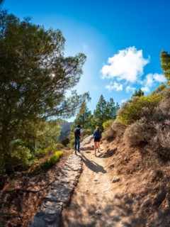 A couple of hikers on the trail up to Roque Nublo in Gran Canaria, Canary Islands. vertical photo