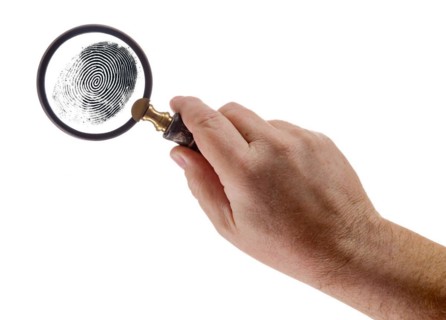 Male hand holding magnifying glass viewing A fingerprint on a white background