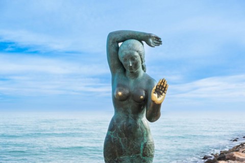 Bust of a siren or mermaid with worn hands and breasts in Sitges, Spain, Europe