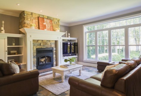 Brown leather sofa, sitting chairs and artificial stone fireplace in the living room with earth