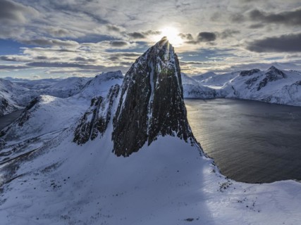 Aerial view of Bergen by the sea, fjord, sunbeams, winter, snow, Mount Segla, Senja, Troms, Norway,