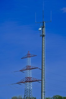 Electricity pylon with high-voltage lines and mobile phone mast near the Avacon substation