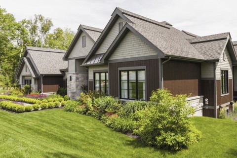 Contemporary natural stone and brown stained wood and cedar shingles clad luxurious bungalow style
