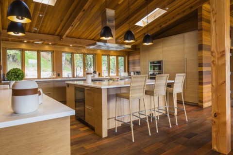 Bamboo wood buffet and island with white quartz countertops and high wicker chairs, cabinets in