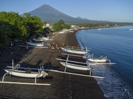 Fishermen loading fish from their outrigger boats in the morning on the black beach of Amed, Amed,