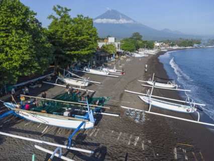 Fishermen loading fish from their outrigger boats in the morning on the black beach of Amed, Amed,