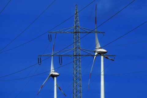 Power pylon with high-voltage lines and wind turbines at the Avacon substation Helmstedt,