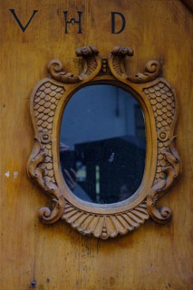Historic wooden front door with window and inscription VHD in a heritage-protected building in the