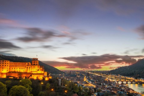 View over an old town with castle or palace rune in the evening at sunset. This town lies in a