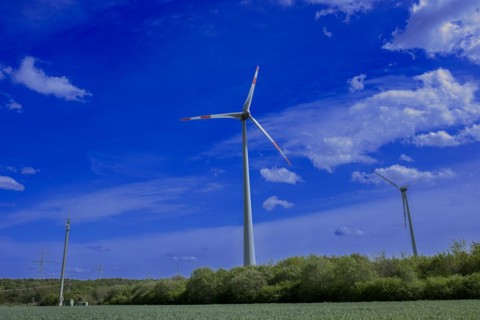 Power pylons with high-voltage lines, mobile phone mast and wind turbines at the Avacon substation