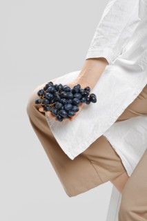 Nutritionist holds a bunch of ripe grapes in her hand