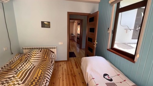 Interior of a hotel room with a double bed and wooden floor