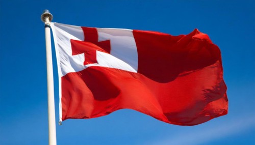 The flag of Tonga, fluttering in the wind, isolated, against the blue sky