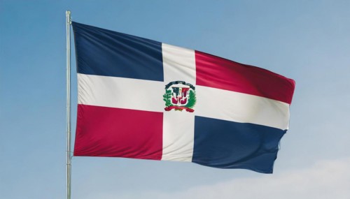 The flag of the Dominican Republic flutters in the wind, isolated against a blue sky