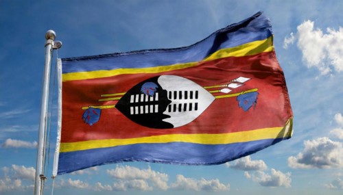 The flag of Swaziland, Kingdom of Eswatini, flutters in the wind, isolated, against the blue sky