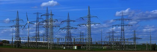 Power pylons with high-voltage lines and wind turbines at the Avacon substation in Helmstedt,