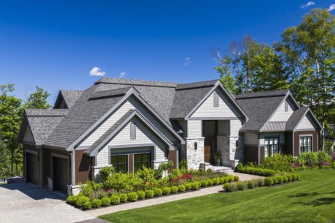 Contemporary natural stone and brown stained wood and cedar shingles clad luxurious bungalow style