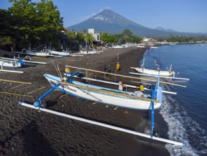 Fishermen loading fish from their outrigger boats in the morning on the black beach of Amed, Amed,