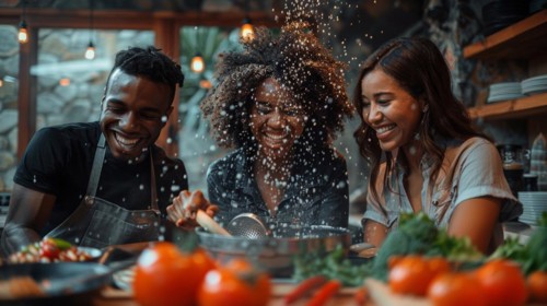 Two women and a man are joyfully engaging in playful cooking, creating a fun atmosphere in a