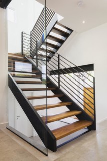 American walnut wood and black powder coated cold rolled steel stairs inside modern cube style