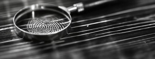 Banner of magnifying glass resting on a fingerprint on paper. generative AI, AI generated