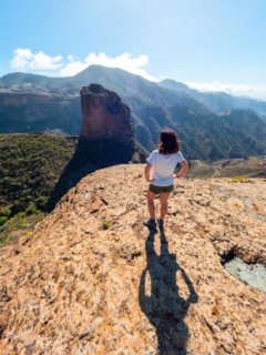 A woman with her back turned at the Roque Palmes viewpoint near Roque Nublo in Gran Canaria, Canary