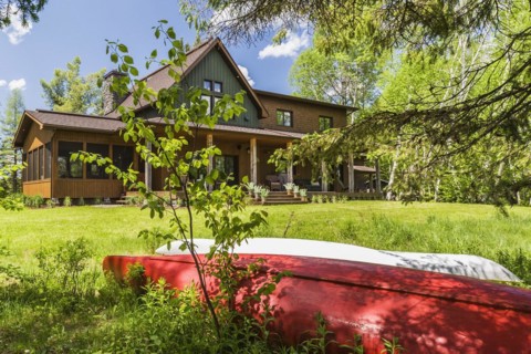 Rear view of brown and green stained spruce wood and cedar shingle siding LEED certified Country