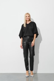 Beautiful elegant blonde woman in black blouse and leather trousers