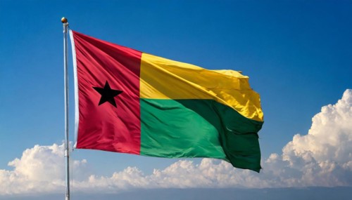 The flag of Guinea-Bissau, fluttering in the wind, isolated, against the blue sky
