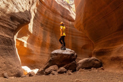 A woman in a yellow t-shirt in the limestone canyon Barranco de las Vacas in Gran Canaria, Canary