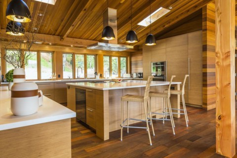 Bamboo wood buffet and island with white quartz countertops and high wicker chairs, cabinets in