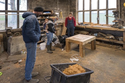 Family inspecting the table built by their son in the workshop, Mecklenburg-Vorpommern, Germany,