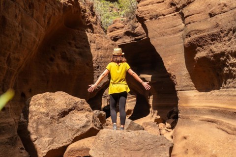 A woman with a hat in the limestone canyon Barranco de las Vacas on Gran Canaria, Canary Islands