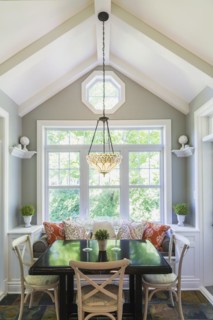 Wooden breakfast table with sitting bench and chairs in the kitchen with earth tone slate flooring