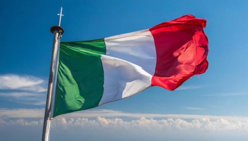 The flag of Italy flutters in the wind, isolated against a blue sky