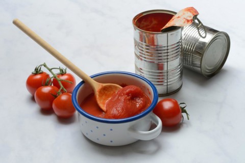 Tinned tomatoes in a bowl, tin can and tomatoes